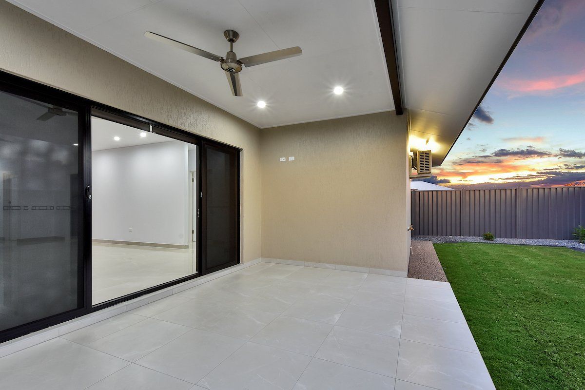 There is a ceiling fan on the patio of a house.