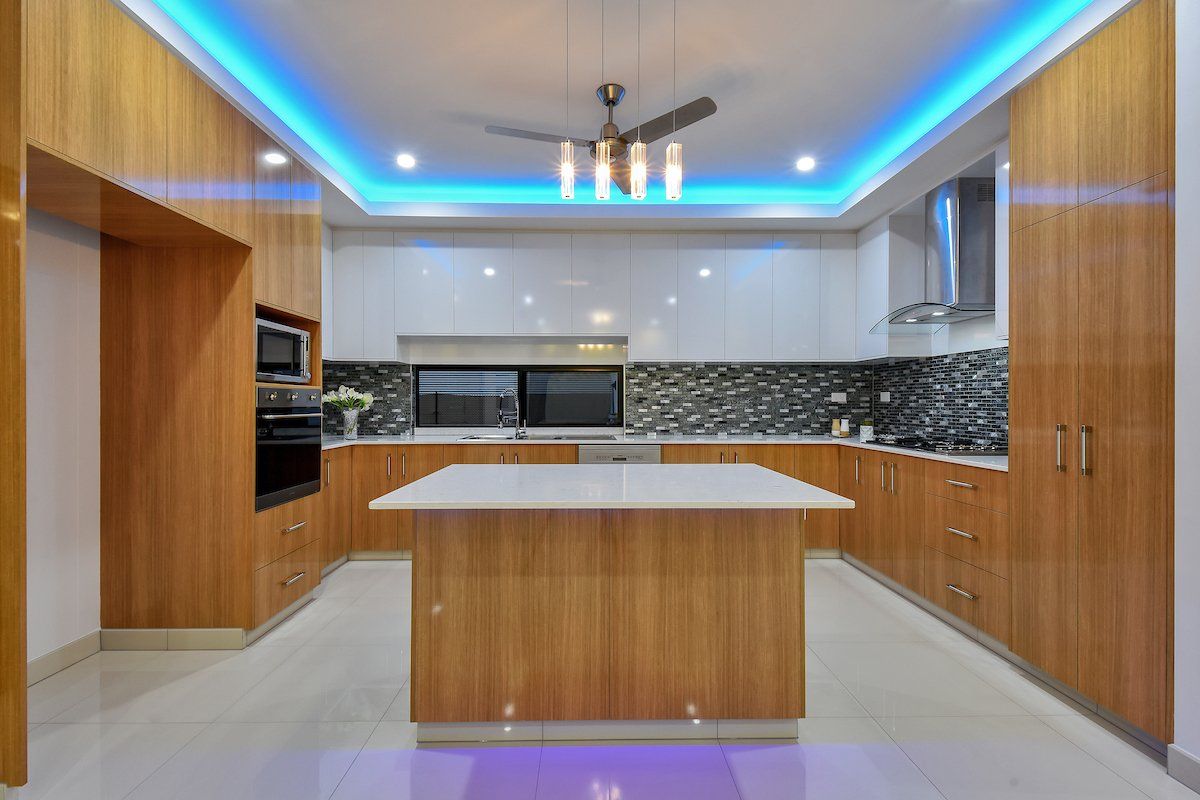 A kitchen with a large island in the middle and a ceiling fan.