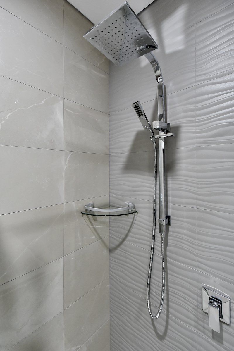 A close up of a shower head in a bathroom.