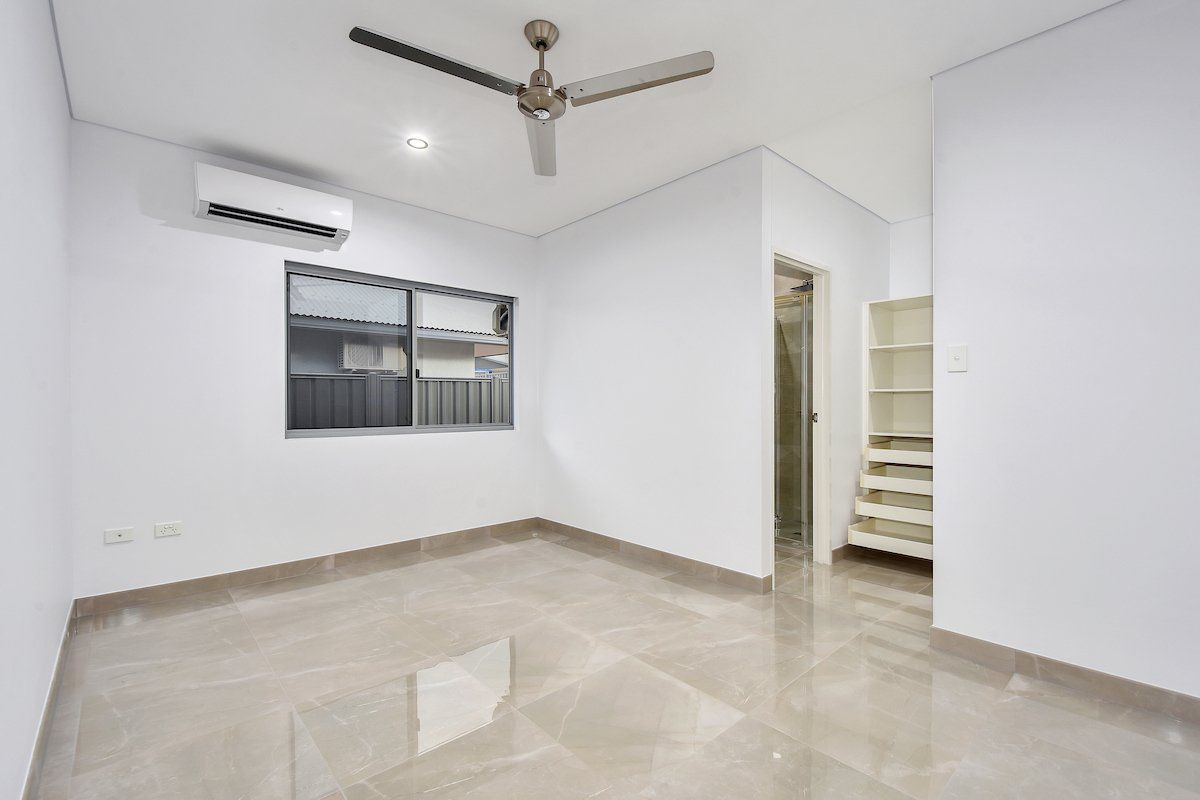 An empty room with a ceiling fan and a window.