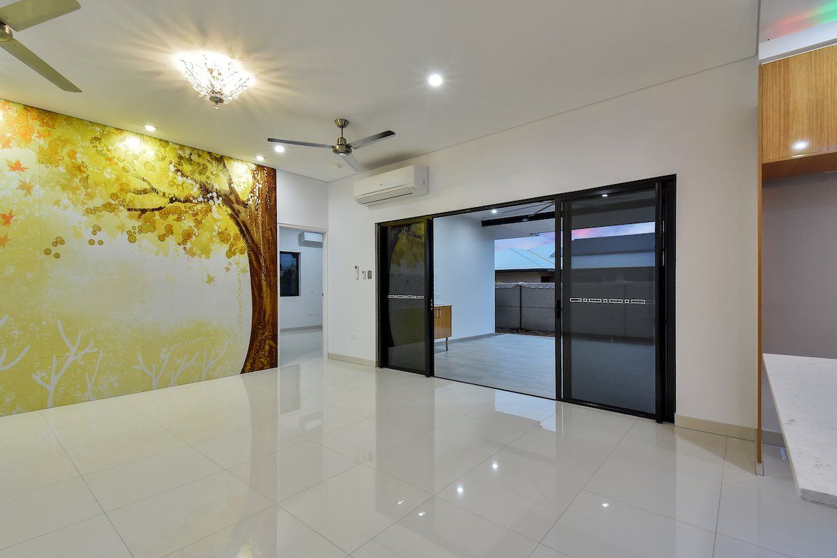 A living room with a painting of a tree on the wall.