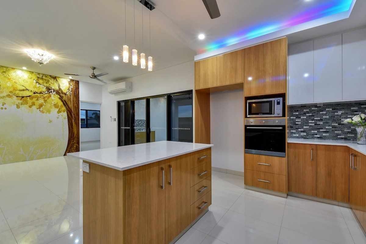A kitchen with wooden cabinets and a large island in the middle.
