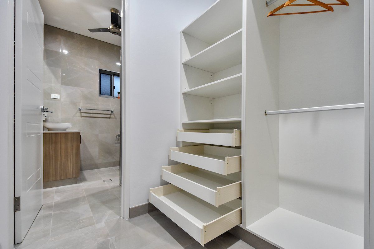 A walk in closet with drawers and shelves in a bathroom.