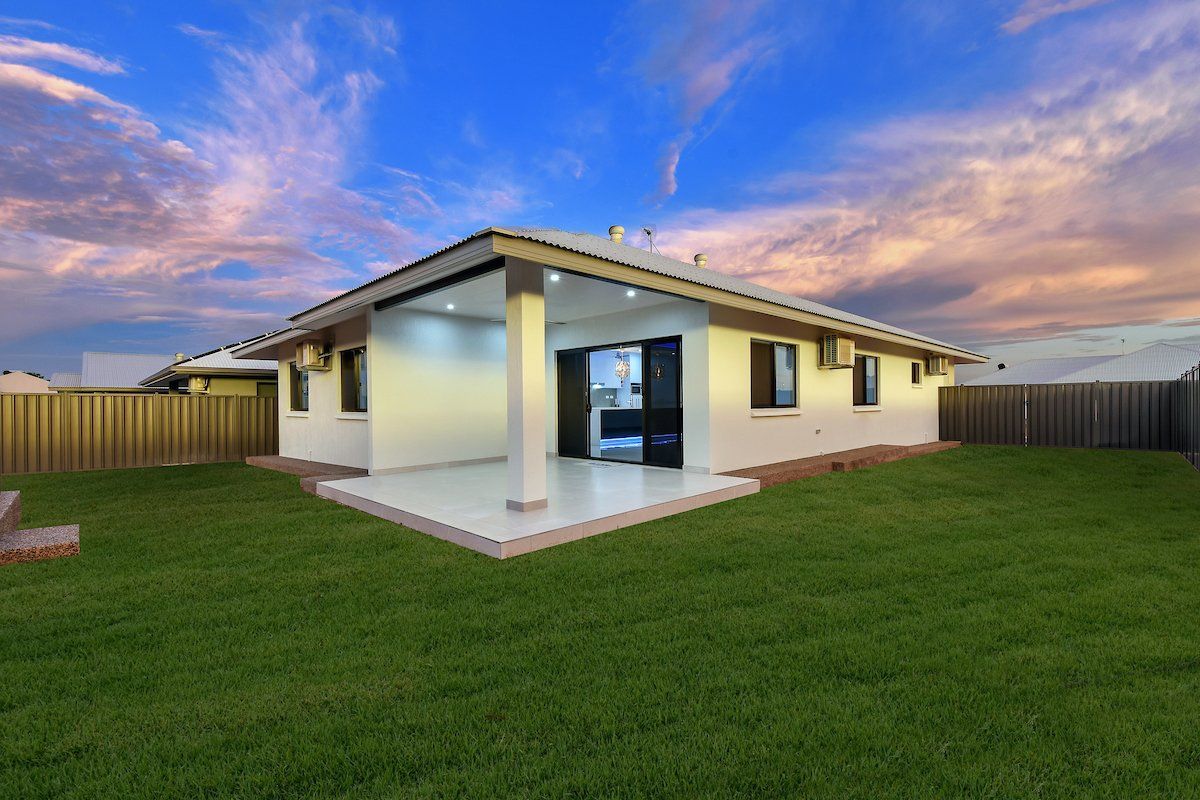 A white house with a large lawn in front of it.