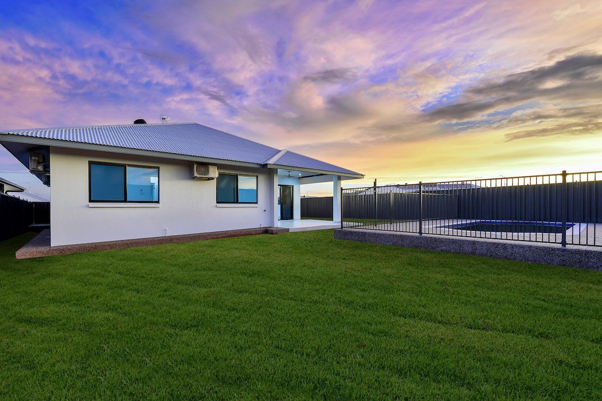 A white house with a large lawn in front of it.