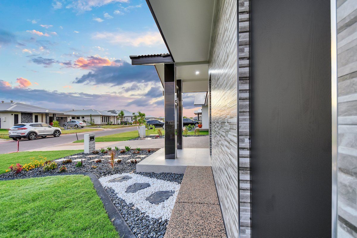 A house with a porch and a car parked in front of it.
