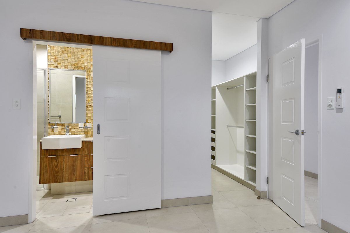 There is a sliding door between the bathroom and the closet.