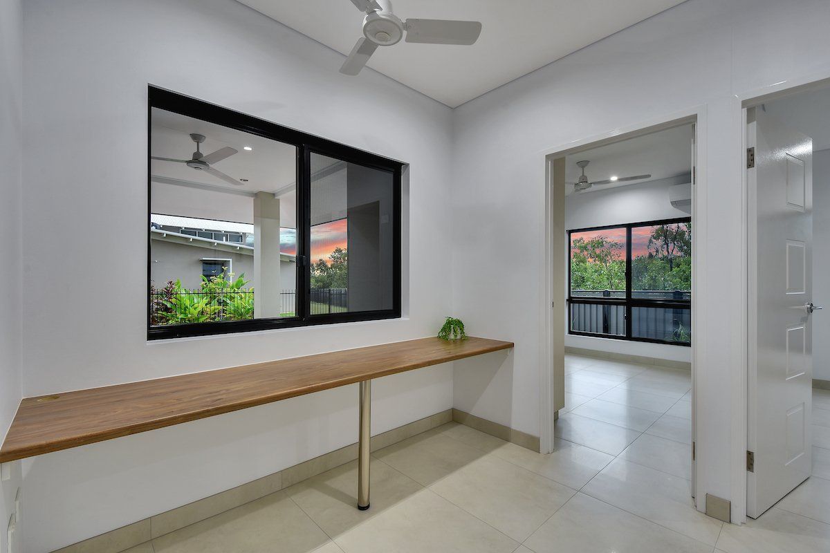 An empty room with a wooden desk and a window.