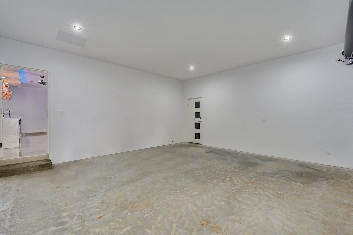 An empty garage with a concrete floor and white walls.
