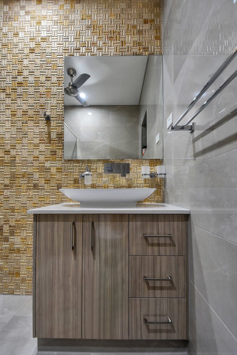 A bathroom with a sink , mirror and ceiling fan.