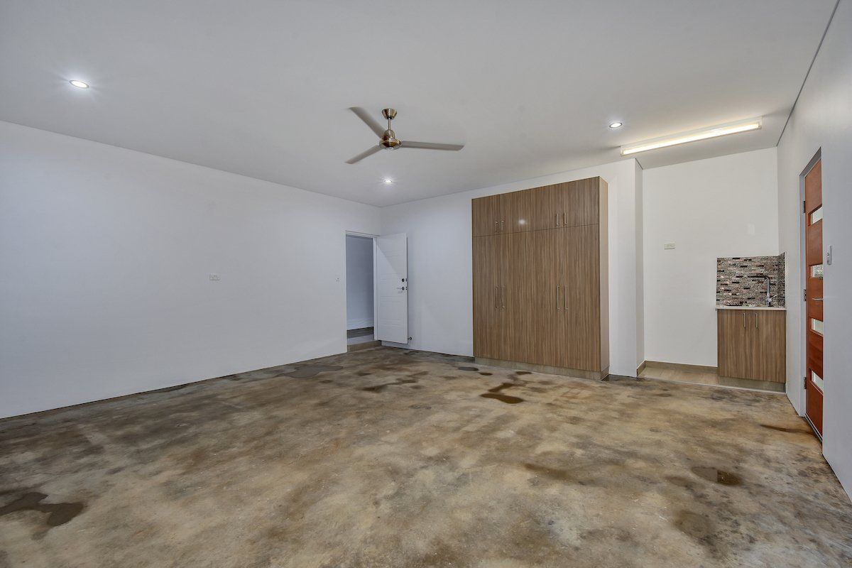 An empty room with a ceiling fan and a concrete floor.