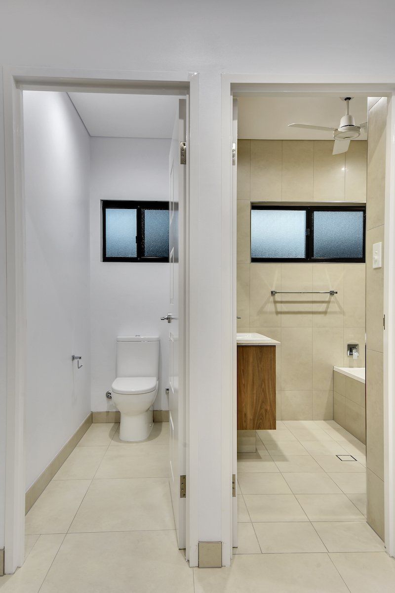 A bathroom with a toilet , sink and window