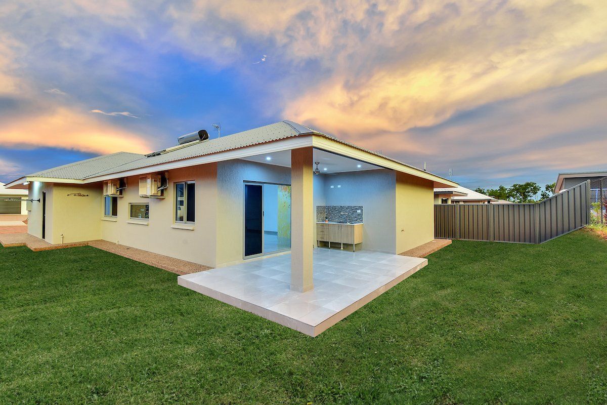 A house with a patio and a fence in the backyard.