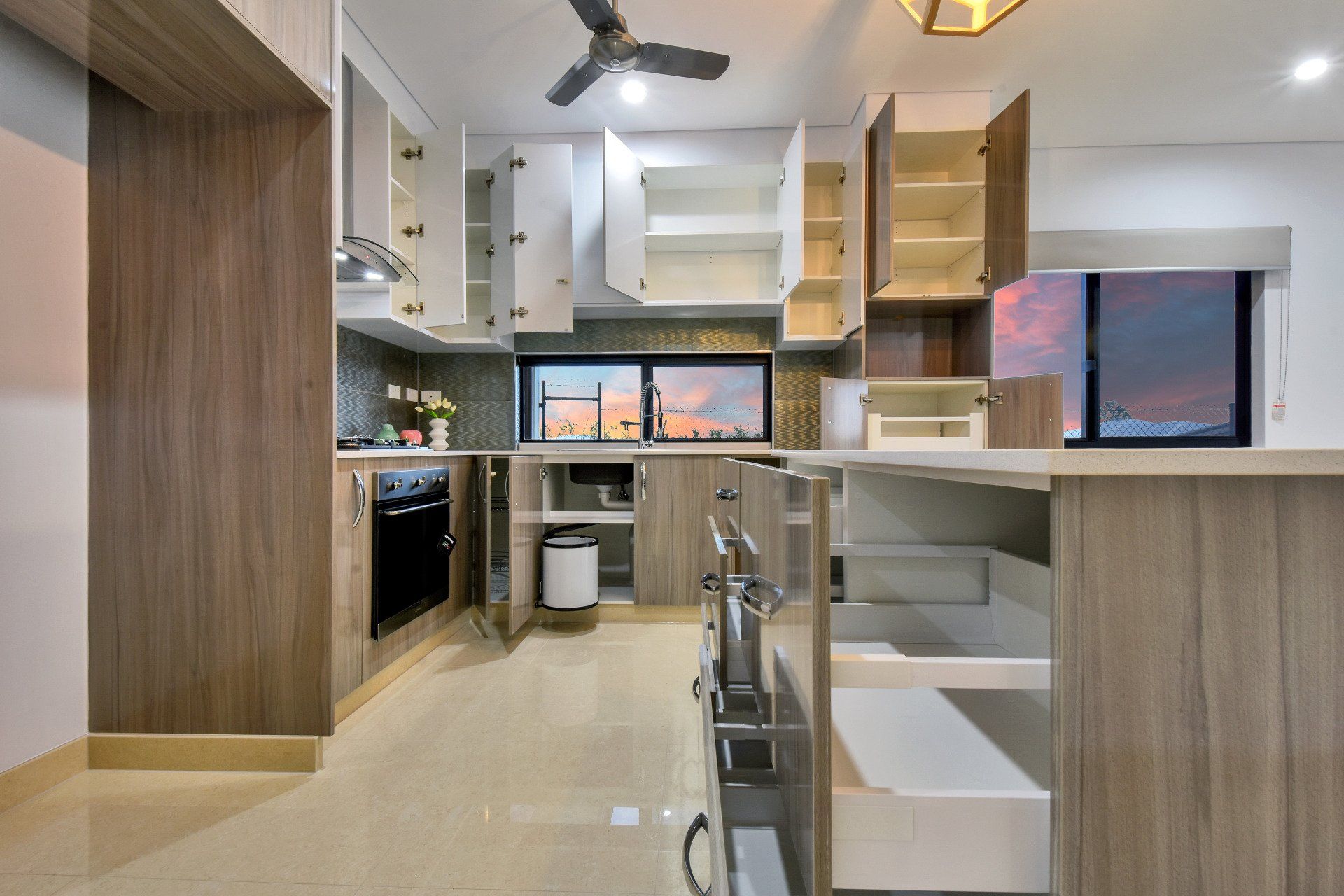 A kitchen with wooden cabinets and a ceiling fan
