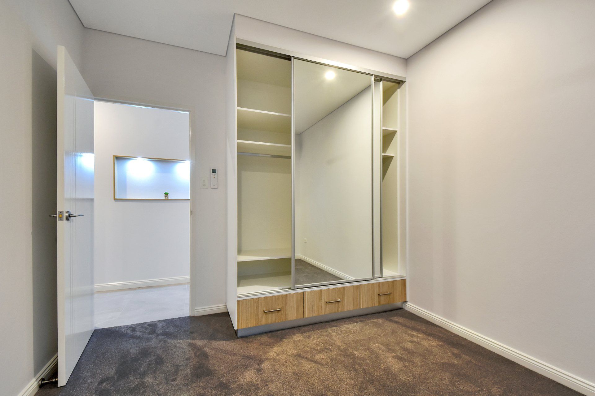 An empty bedroom with a large sliding glass door