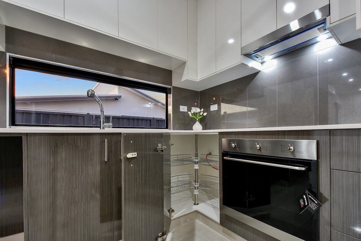 A kitchen with white cabinets and a black oven