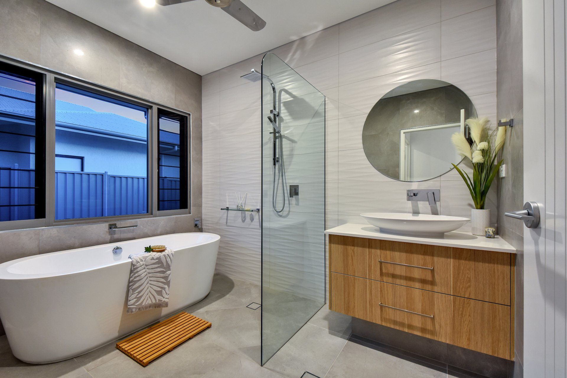 A bathroom with a bathtub , sink , mirror and walk in shower.