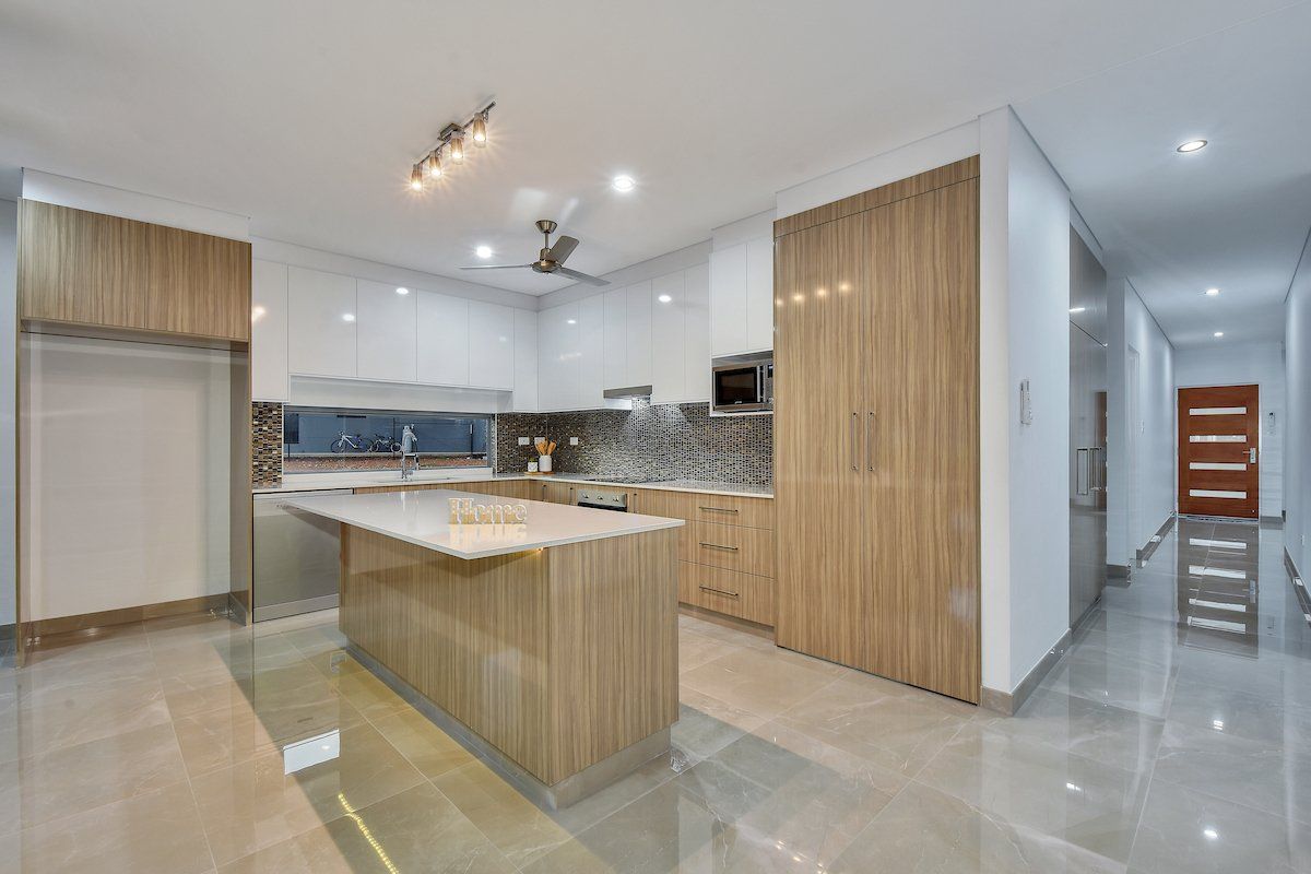A kitchen with a large island and white cabinets
