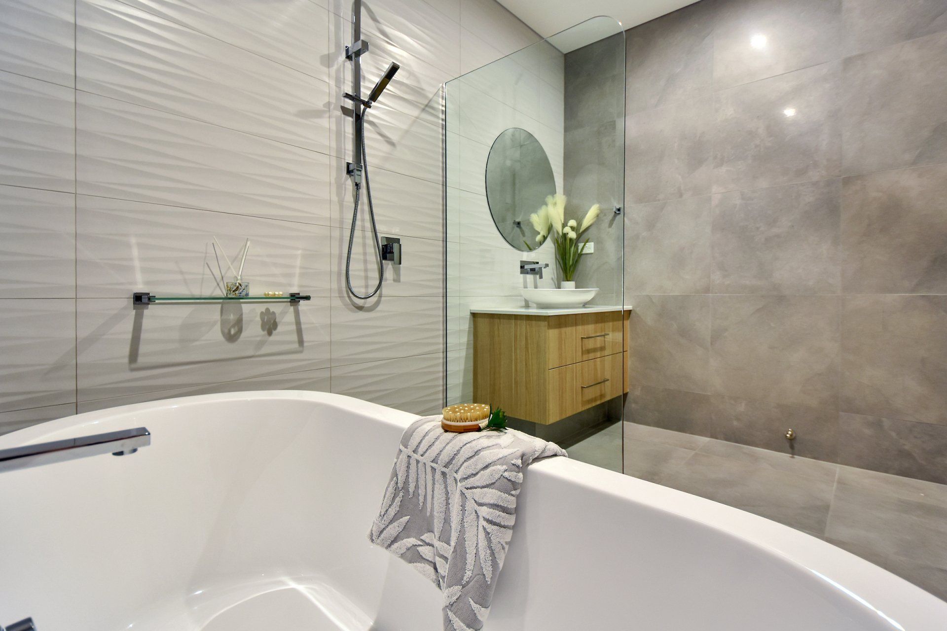 A bathroom with a bathtub , sink , shower and mirror.