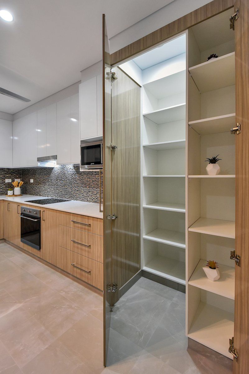 A kitchen with wooden cabinets and white shelves.