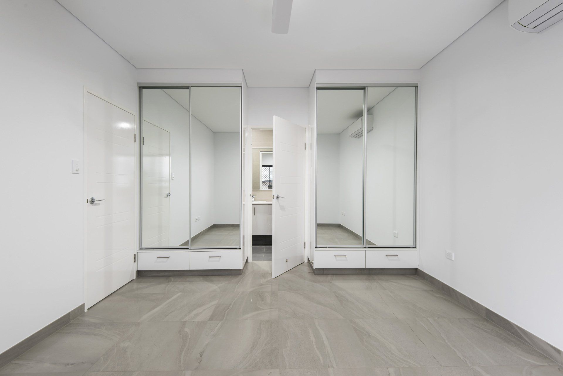 A large empty room with a lot of mirrors on the walls.