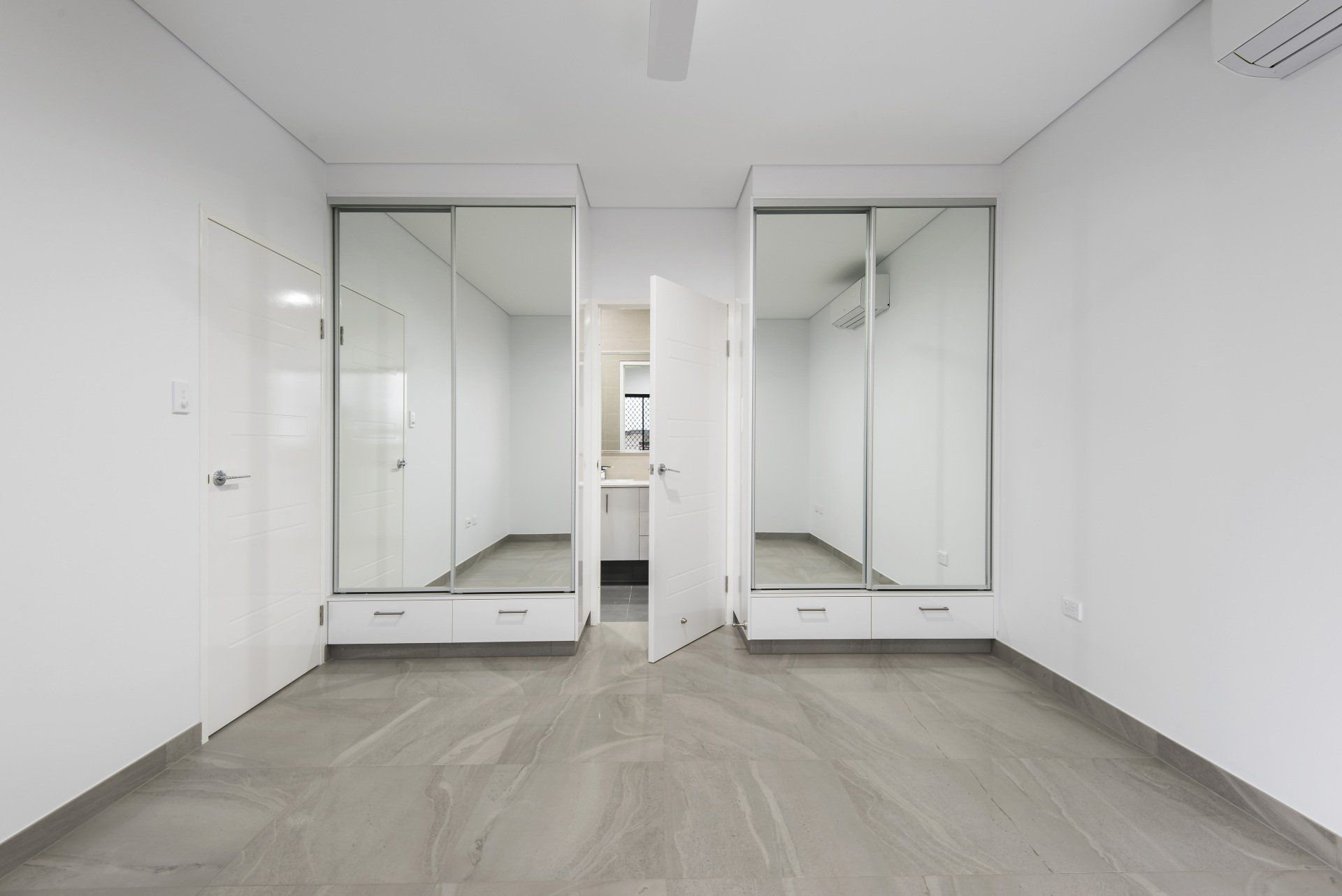 A large empty room with a lot of mirrors on the wall.