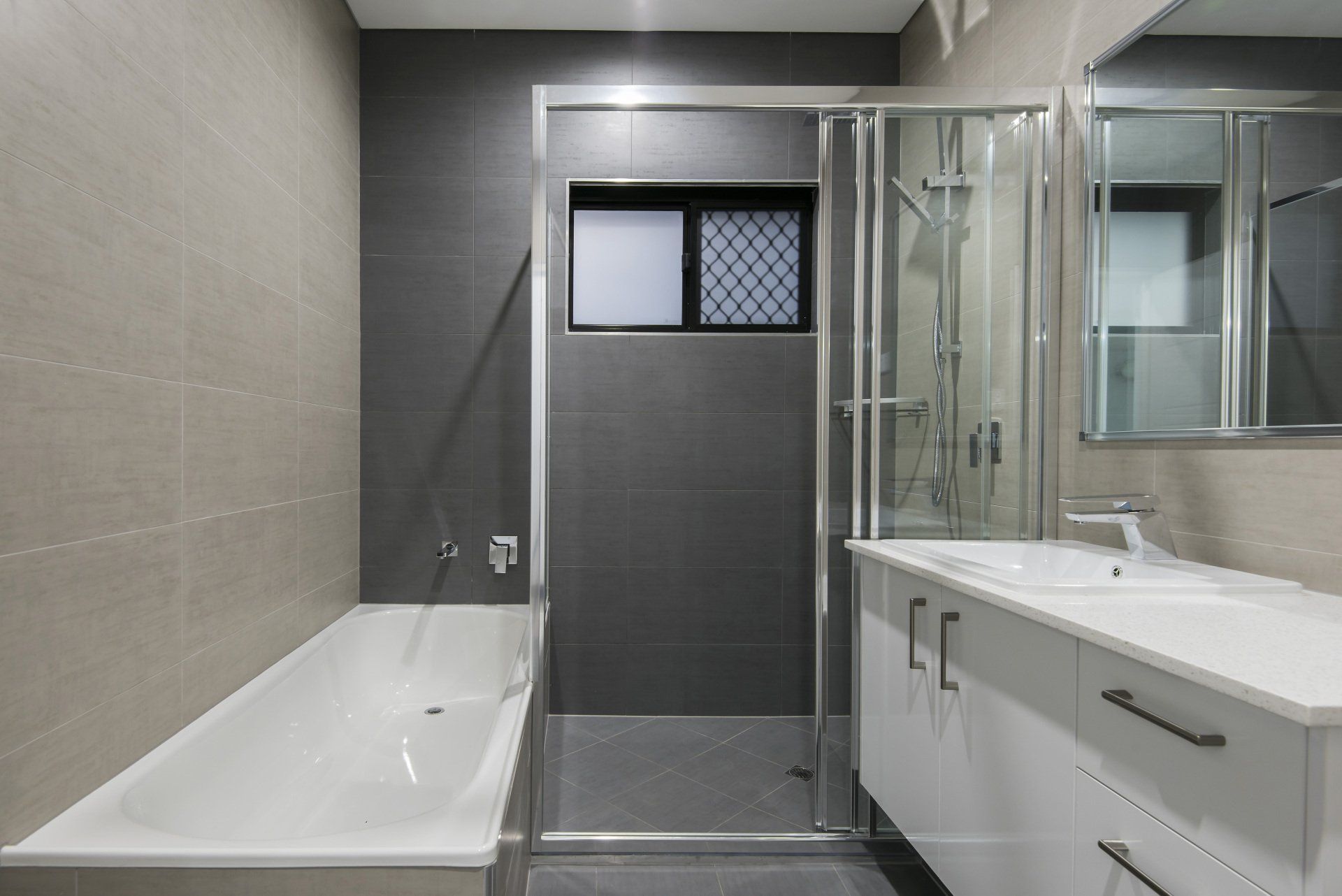 A bathroom with a bathtub , sink , and shower.