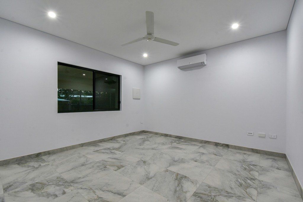 An empty room with a ceiling fan and a window.