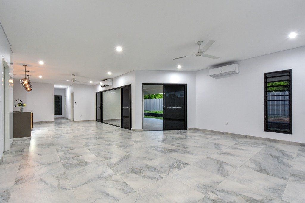 A large empty room with marble floors and white walls.