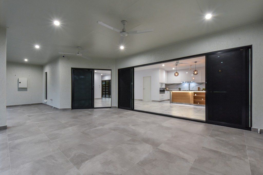A large empty room with sliding glass doors and a ceiling fan.