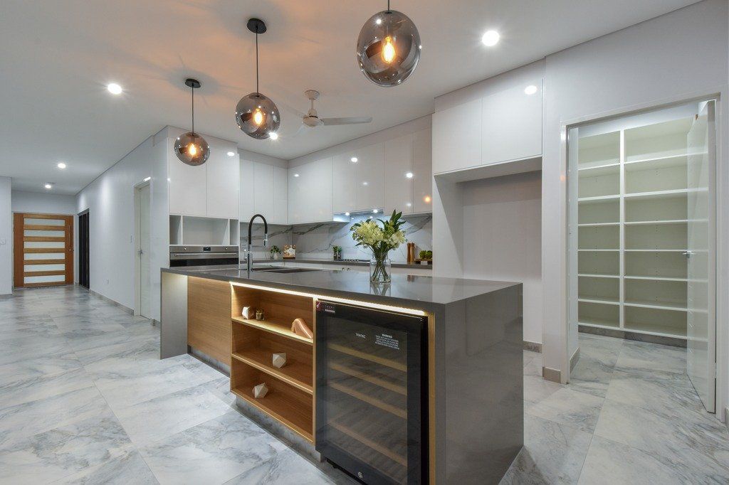 A kitchen with a large island and a wine cooler.