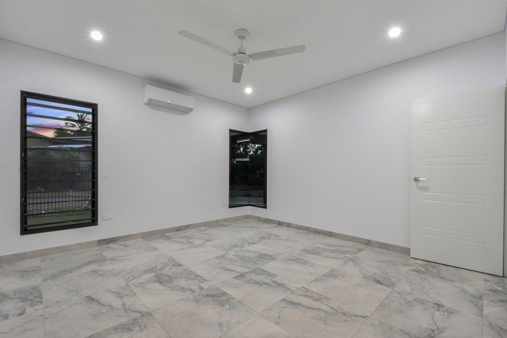 An empty room with a ceiling fan and a window.