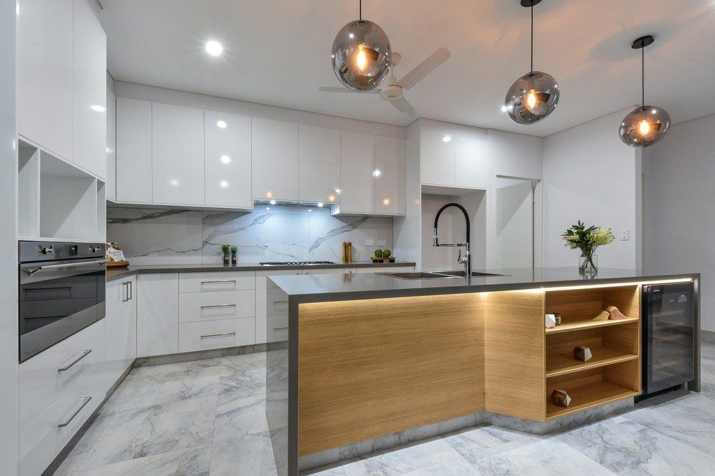 A kitchen with white cabinets and a large island in the middle