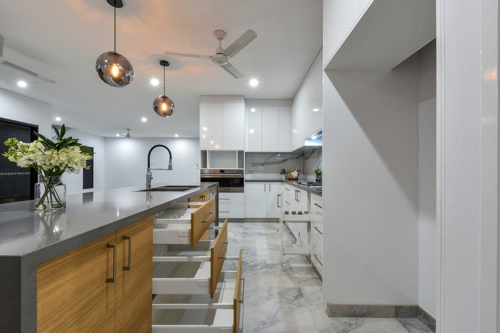 A kitchen with a lot of drawers and a ceiling fan.