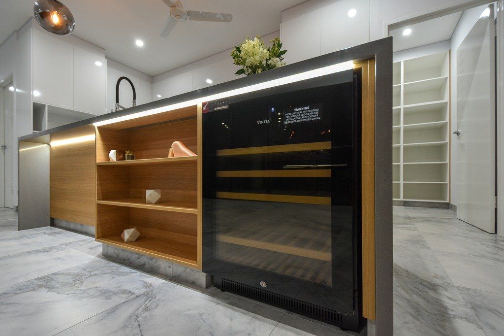 A kitchen with a large island and a wine cooler.
