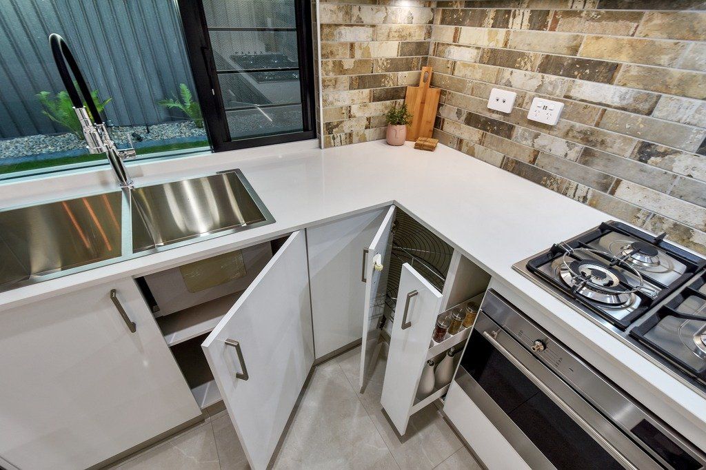 A kitchen with stainless steel appliances and white cabinets.