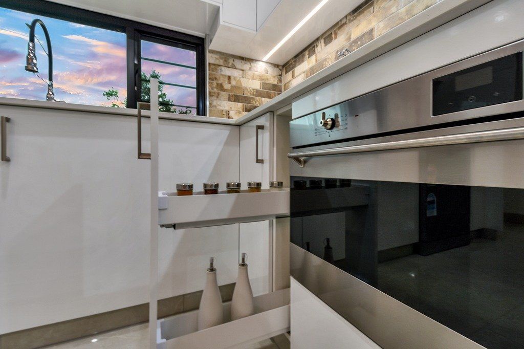A kitchen with white cabinets and a stainless steel oven