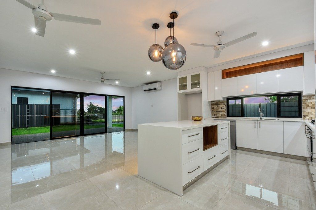An empty kitchen with white cabinets and a large island