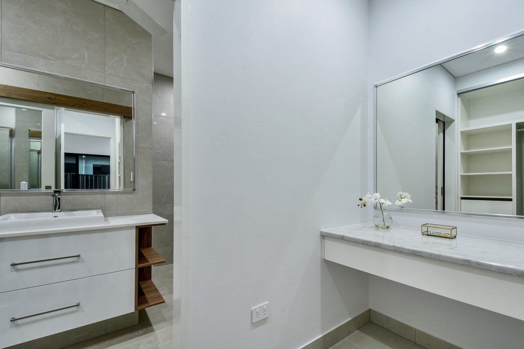 A bathroom with two sinks and two mirrors.
