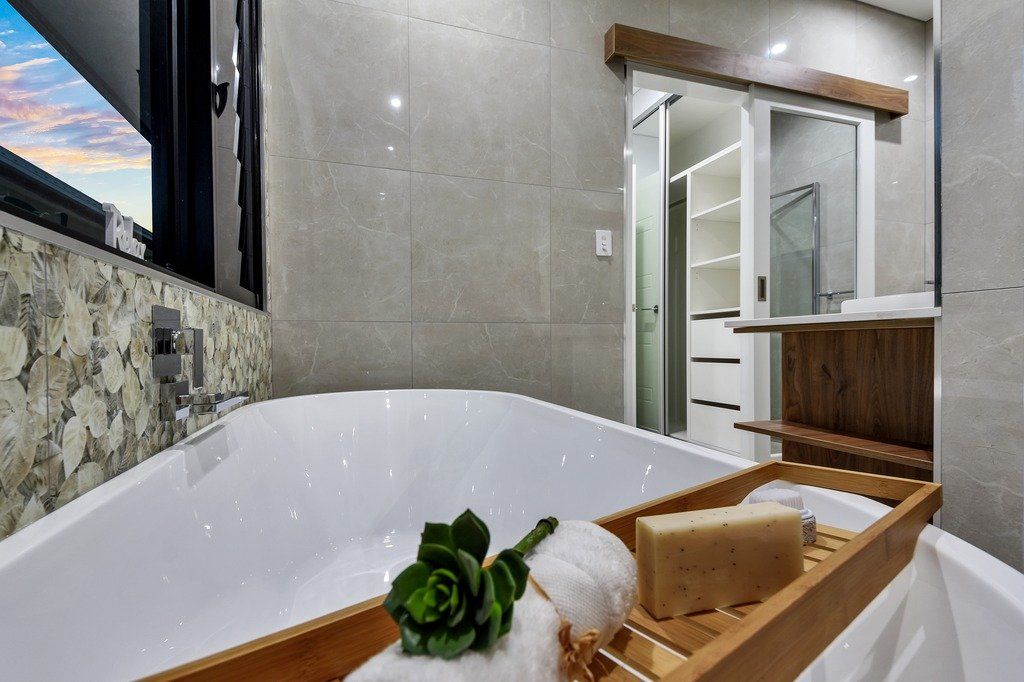 A bathroom with a bathtub and a tray of soap on it.