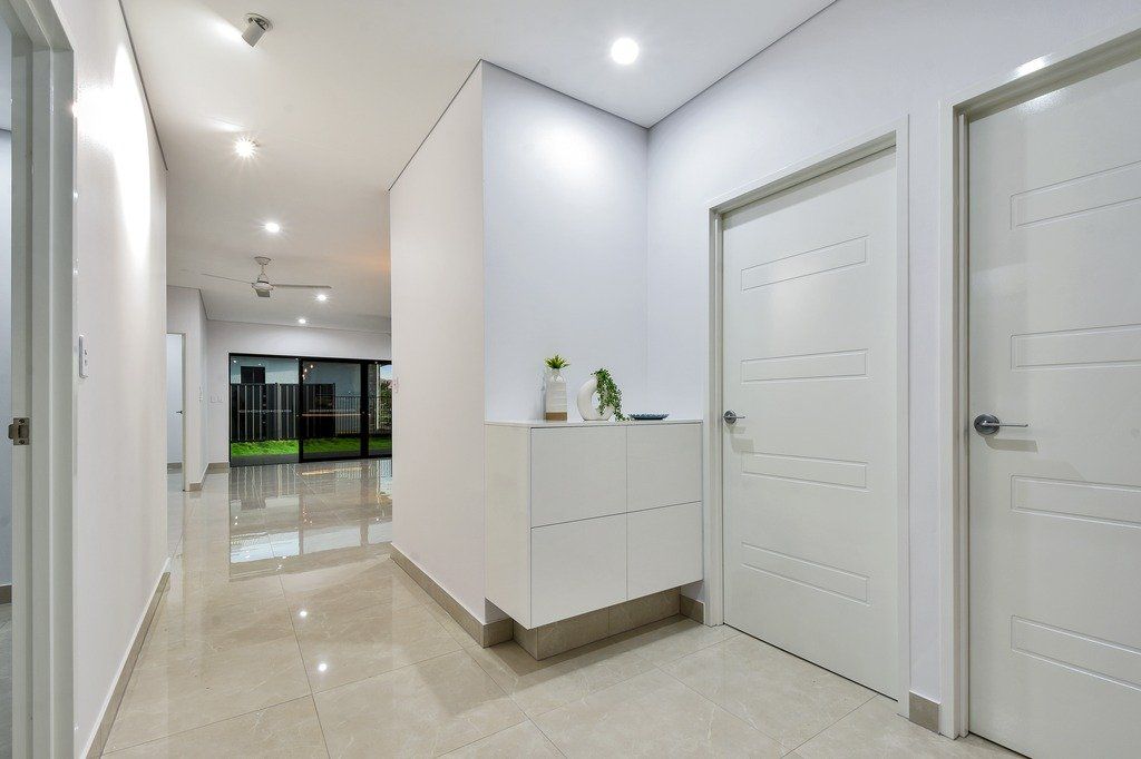 A long hallway with white walls and white doors