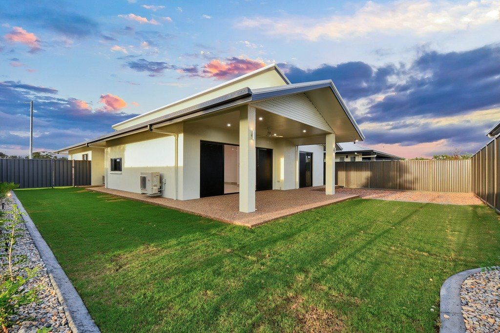 A small house with a large lawn in front of it.