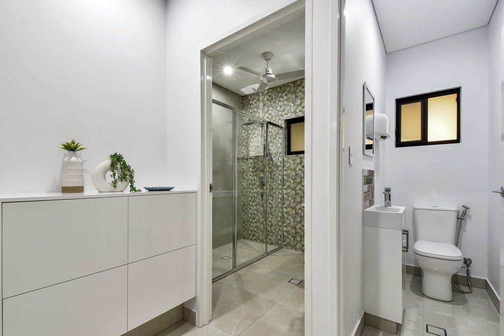 A bathroom with a toilet , sink and walk in shower.