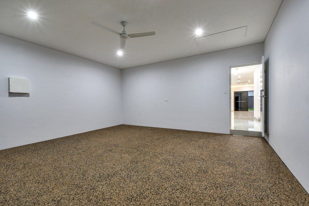 An empty room with a ceiling fan and a carpeted floor.