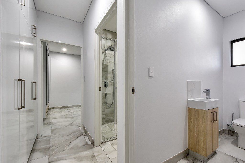 A bathroom with a sink , toilet and walk in shower.