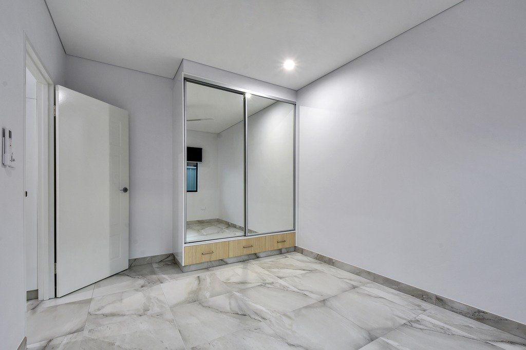 An empty room with a large mirrored wardrobe.