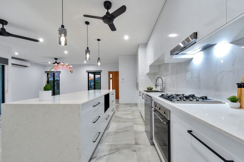 A kitchen with white cabinets and stainless steel appliances