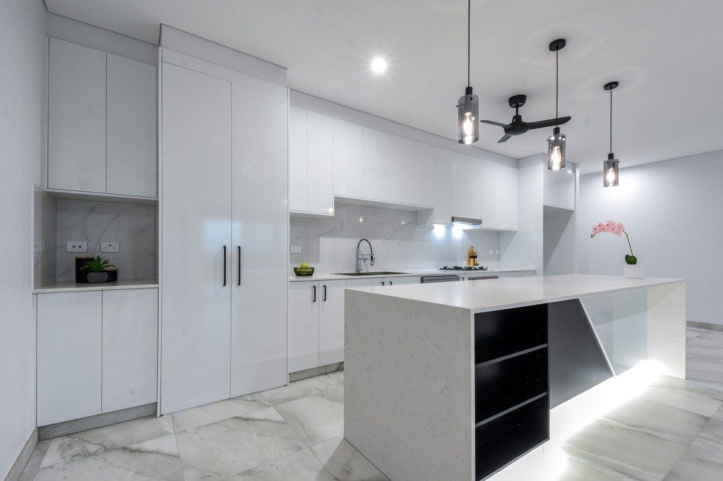 A kitchen with white cabinets and a large island