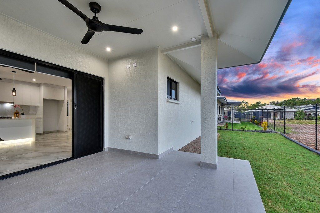 There is a ceiling fan on the patio of a house.