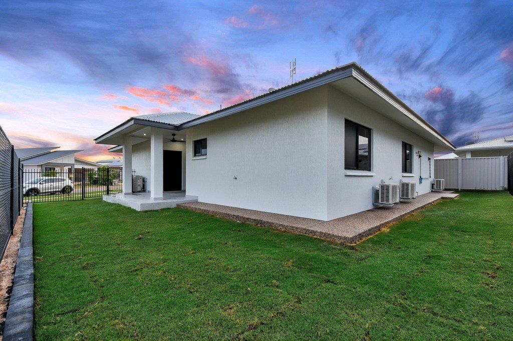A white house with a large lawn in front of it.